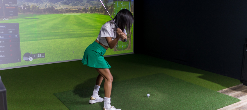 Woman playing golf at Fairway Golf simulator facility in San Antonio