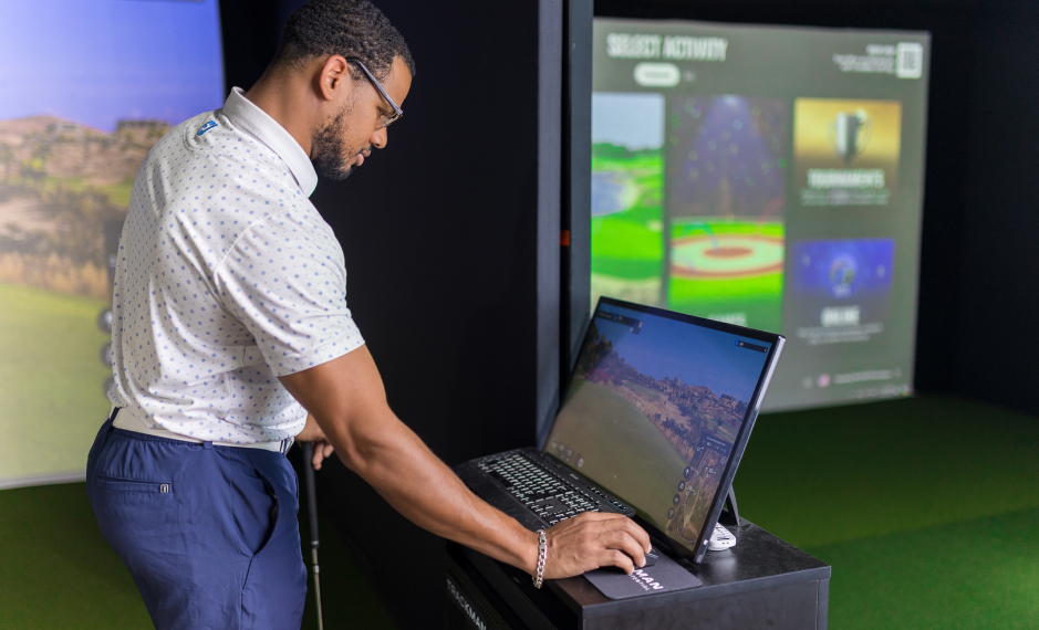 Man checking tracker and screen play in Fairway Golf Simulator