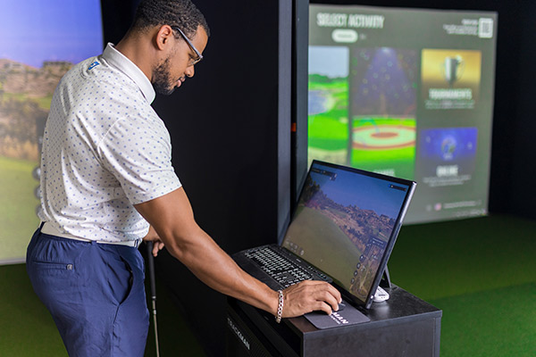 Fairway Golf indoor: man reviewing Trackman