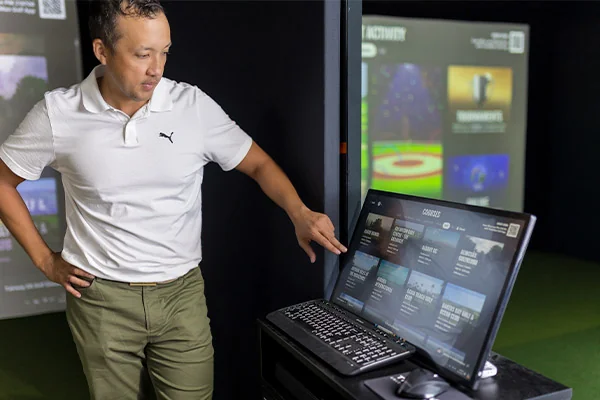 Man showing track simulator results analytics for indoor golf at Fairway Golf simulator in San Antonio 
