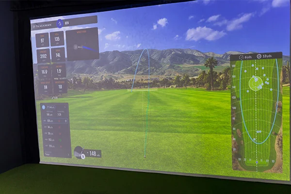 A golf simulator featuring a vibrant green field and golf course, showcasing advanced golfing techniques for improvement.