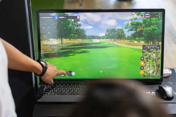 A man is playing golf on a computer screen, showcasing a virtual golf game in action.