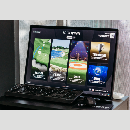 A computer monitor displaying a golf simulation interface with options for practice, courses, games, tournaments, and online activities.